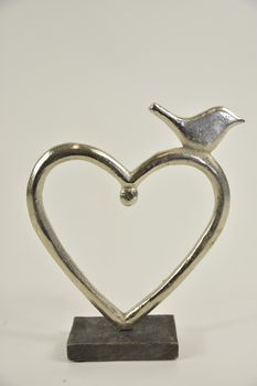 Aluminium hart met vogel op mangohouten voet 18x5x23cm