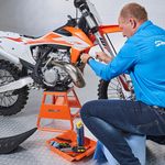 Sleutelen aan de crossmotor op oranje MX-stand