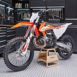 MX stand goud in werkplaats met KTM crosser