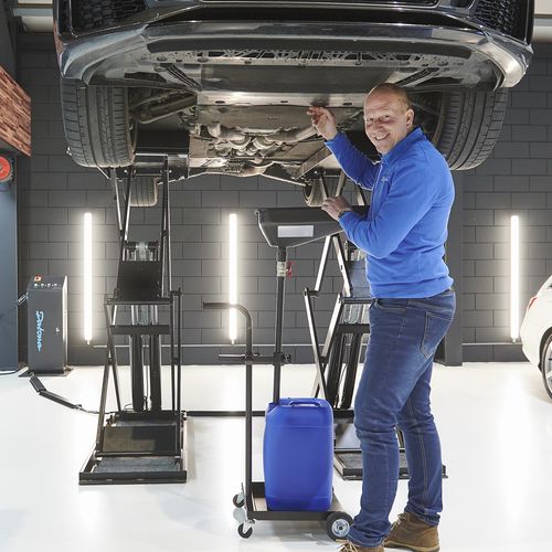Olie opvangen in bak bij werken aan auto