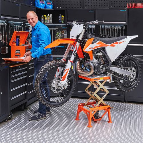 Oranje motor op crosslift met oranje gereedschapskist