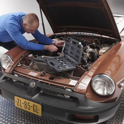 Rintje sleutelt aan bruine auto