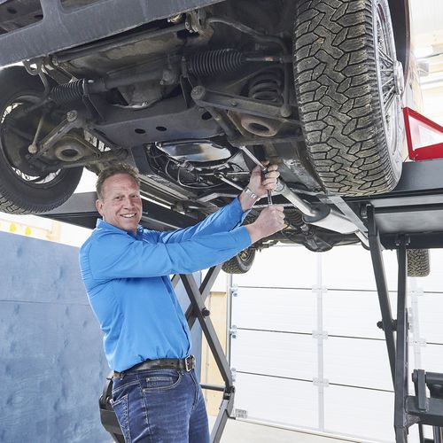 sleutelen aan onderkant auto met schaarlift